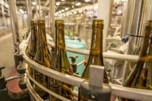 project-4 Close-up view of glass bottles on an industrial production line in a manufacturing facility.