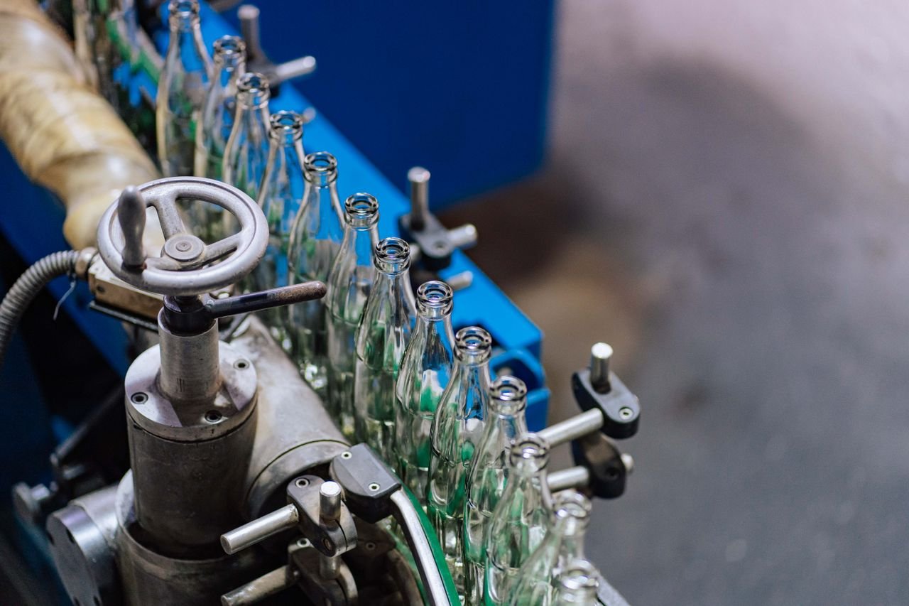 Products Close-up of glass bottling machinery in action, showcasing industrial precision.