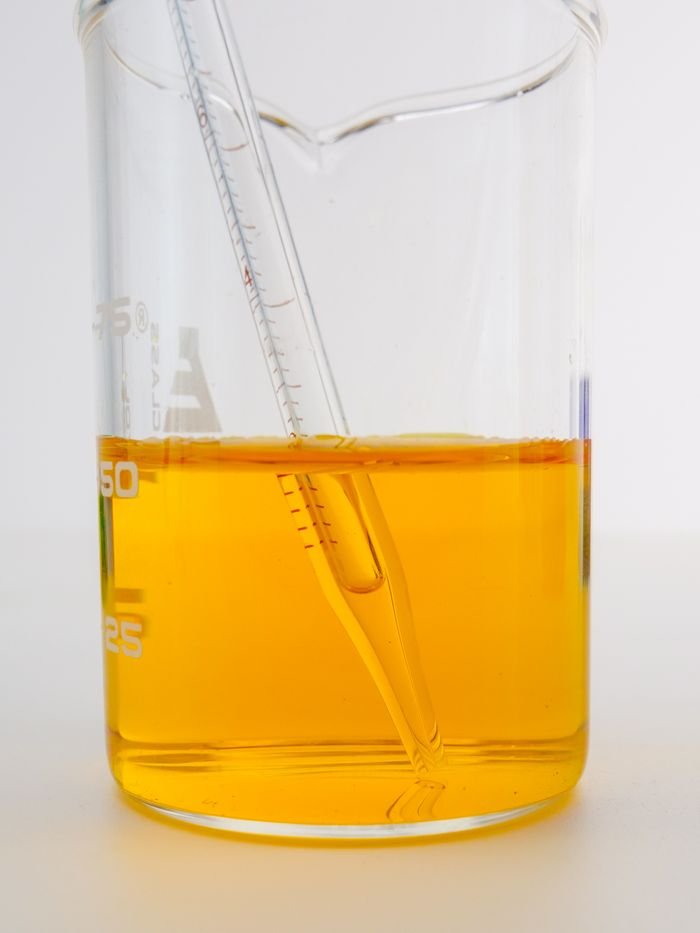 Oleochemicals & Bioenergy Derivatives A detailed view of a yellow liquid in a laboratory beaker with a pipette, perfect for science themes.