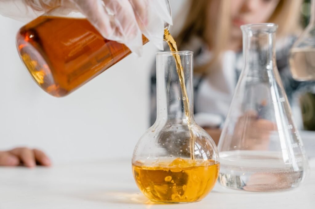 Products A curious child pours liquid into a flask during a science experiment indoors.